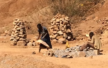 Two men salvaging lead-rich mine piles for resale.